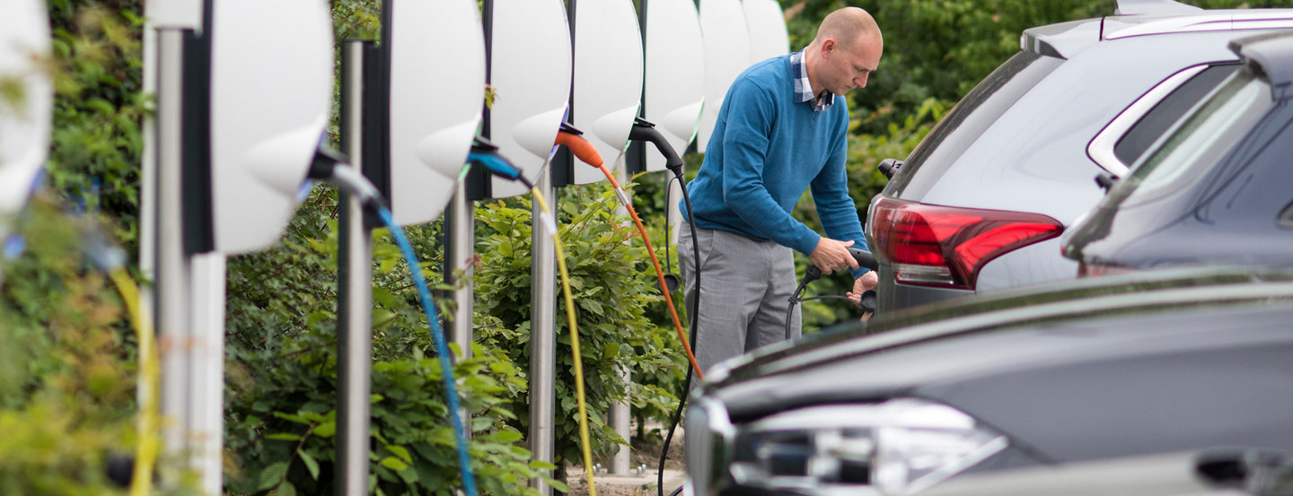 Een medewerker van Fluvius laadt zijn elektrische wagen op