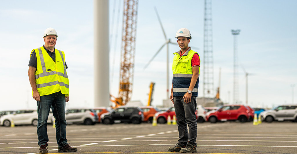 Employees stand in front of the wind park at Zeebrugge